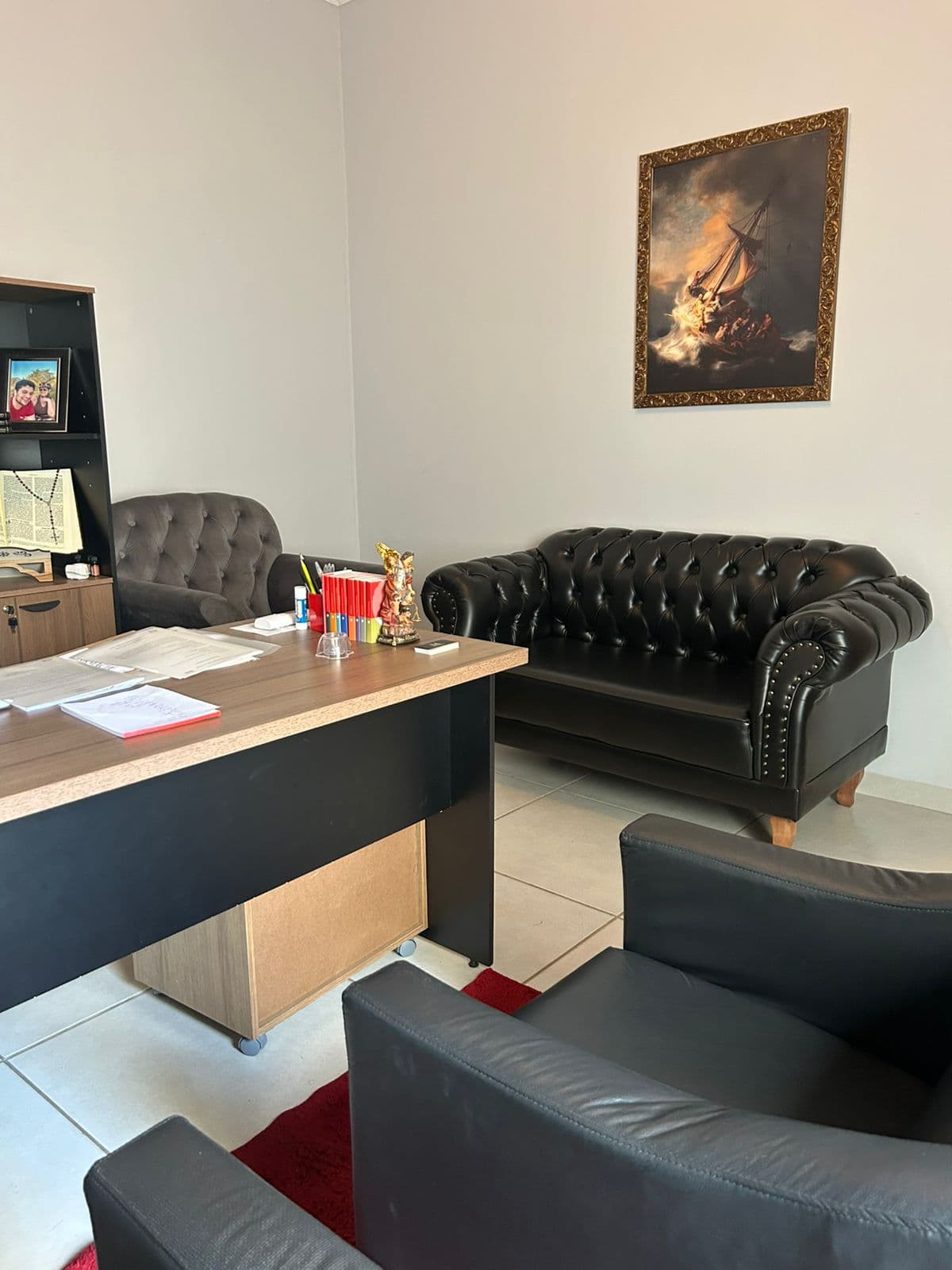 Ambiente de reuniões com sofá e obra clássica no escritório